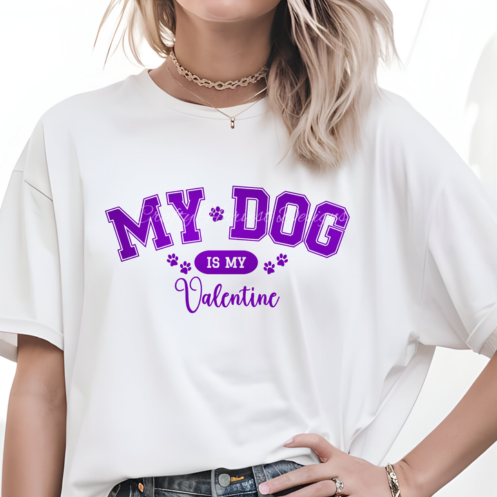 Model wearing a white t-shirt featuring the ‘My Dog Is My Valentine’ design in purple varsity-style text with paw print accents.